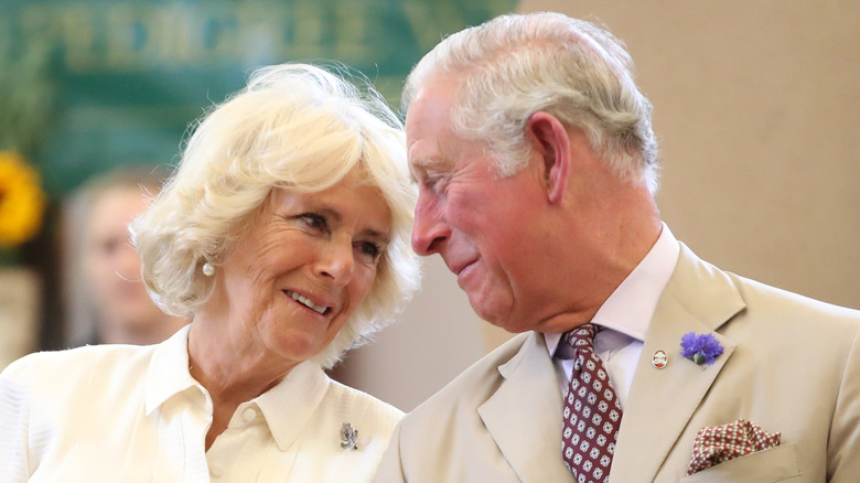 El rey Carlos III y Camilla en un evento, sonriendo cerca