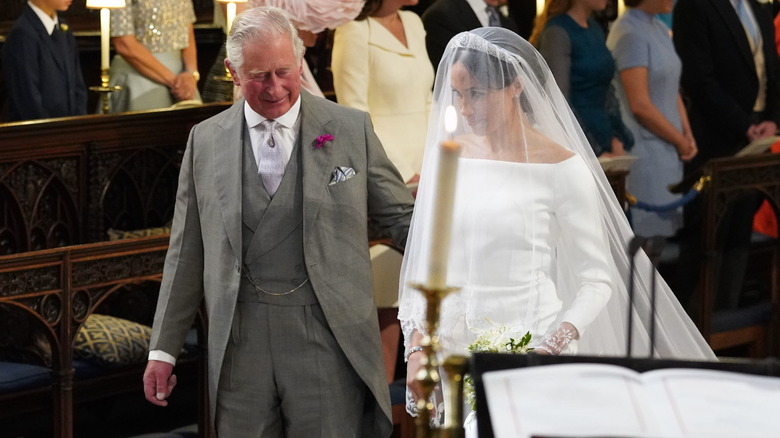 El rey Carlos y Meghan Markle caminando por el altar