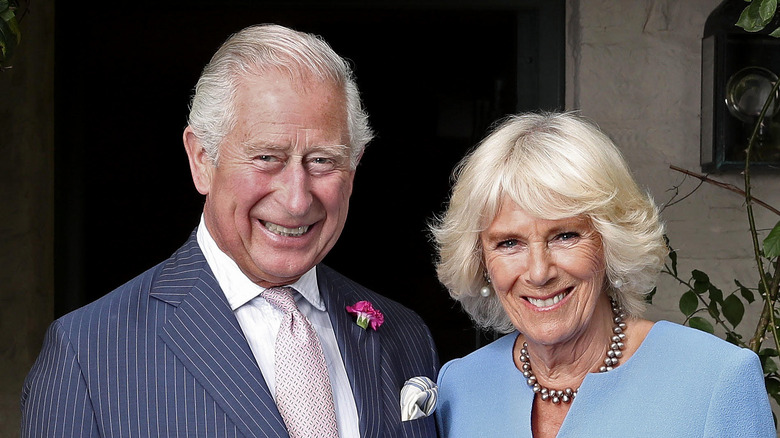 Camilla Parker Bowles y el rey Carlos sonriendo.