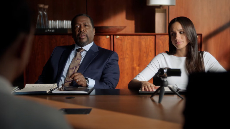 Wendell Pierce y Meghan Markle sentados en una mesa