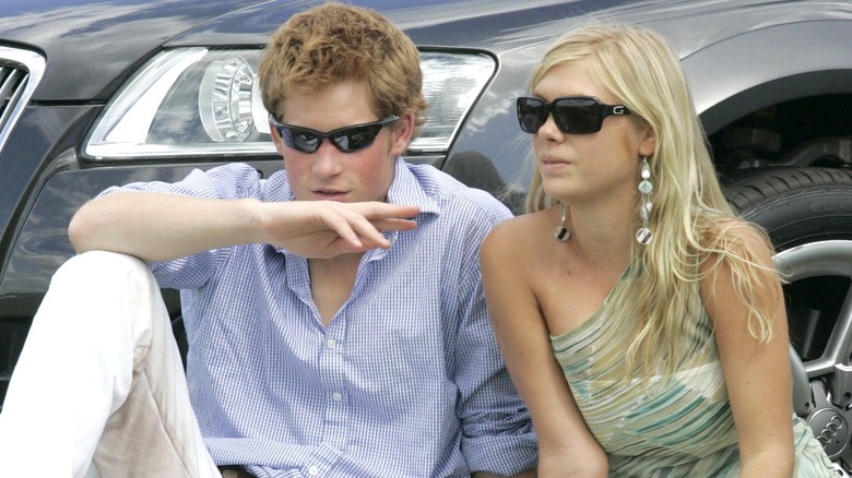 El príncipe Harry y Chelsy Davy sentados en el césped