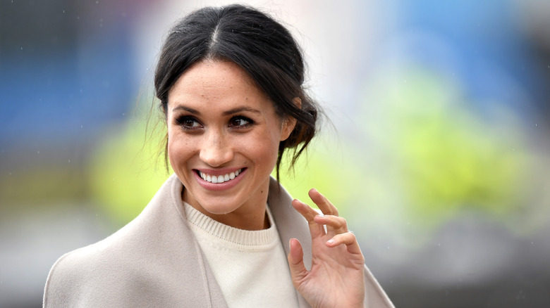 Abrigo crema de Meghan Markle sonriendo