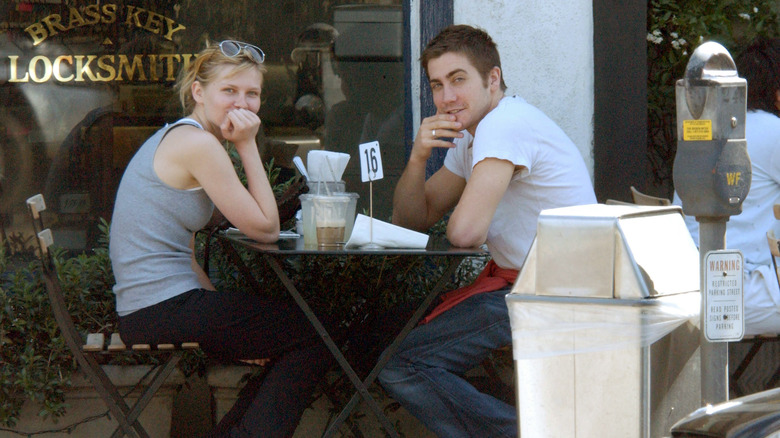 Kirsten Dunst y Jake Gyllenhaal sentados al aire libre