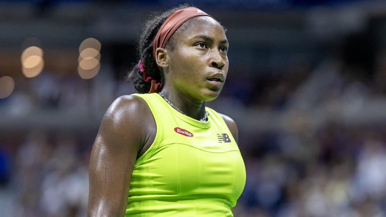 Coco Gauff jugando en la cancha con un traje de tenis verde lima