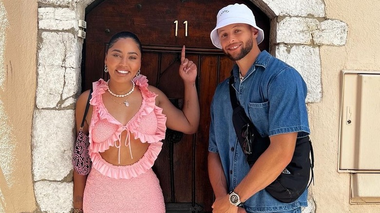 Ayesha y Steph Curry posando frente a la puerta