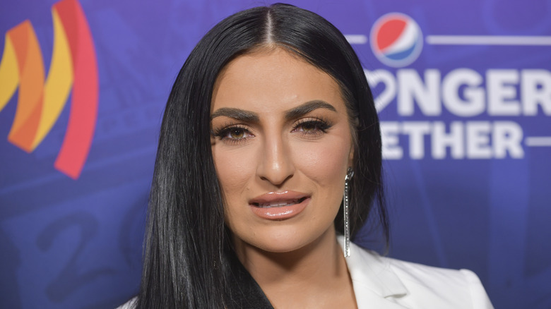 Sonya Deville sonriendo vestida de blanco