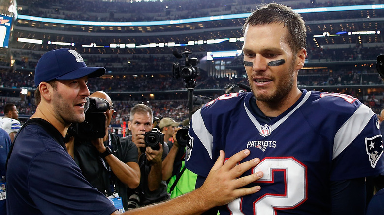 Tony Romo con la mano sobre Tom Brady