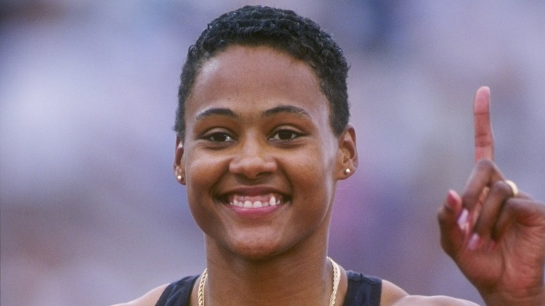 Marion Jones sonriendo y levantando su dedo índice