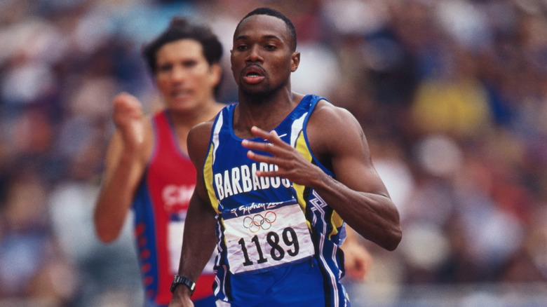 Obadele Thompson corriendo con un competidor detrás de él