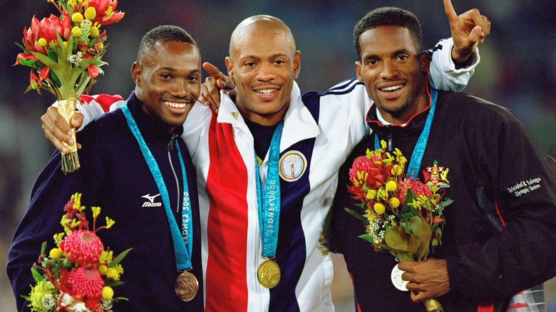 Obadele Thompson, Maurie Greene y Ato Boldon con medallas