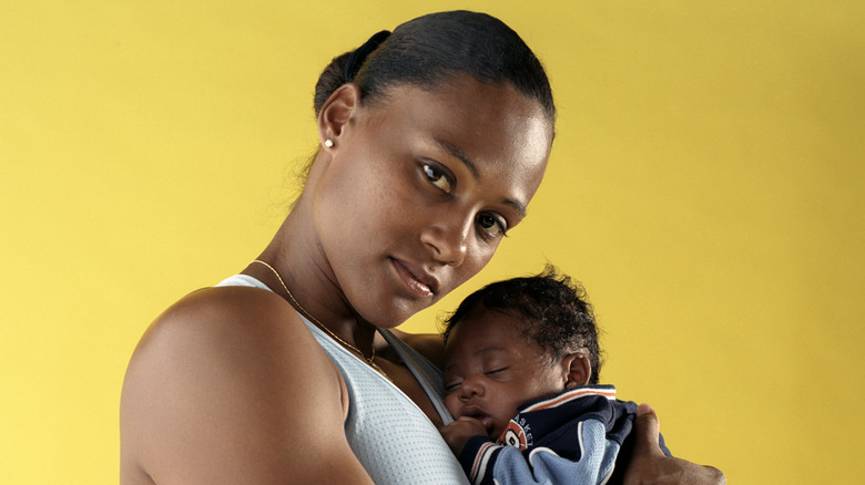 Marion Jones sosteniendo a su hijo