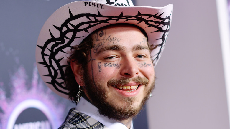 Post Malone sonriendo con sombrero