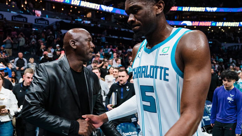 Michael Jordan estrechando la mano de un jugador en el partido de los Charlotte Hornets