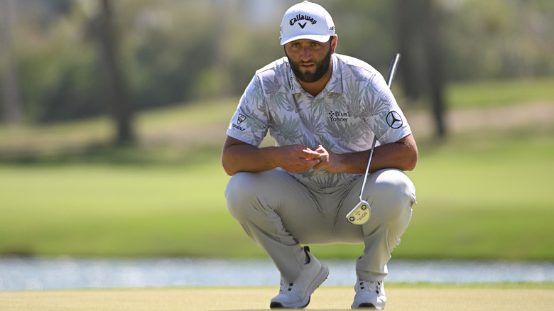 Jon Rahm en cuclillas en un campo de golf