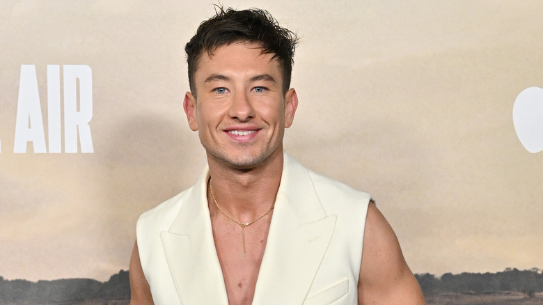 Barry Keoghan sonríe con un traje blanco