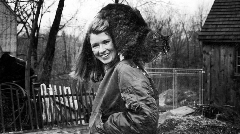 Martha Stewart sonriendo con su gato sobre sus hombros en 1980