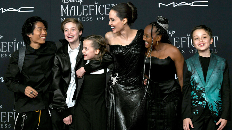 Pax Thien Jolie-Pitt, Shiloh Nouvel Jolie-Pitt, Vivienne Marcheline Jolie-Pitt, Angelina Jolie, Zahara Marley Jolie-Pitt y Knox Leon Jolie-Pitt sonriendo en una alfombra roja