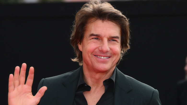 Tom Cruise sonriendo con traje negro