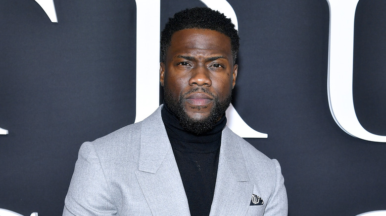 Kevin Hart posando con una chaqueta gris