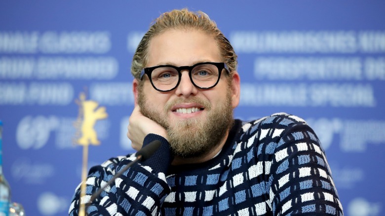 Jonah Hill sonriendo con un suéter azul