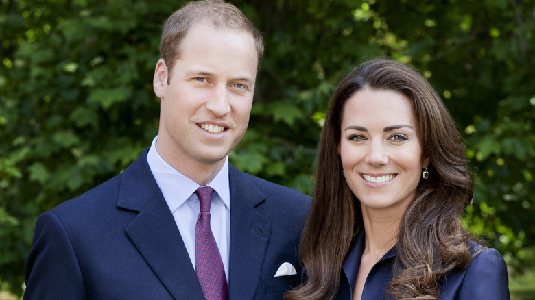 El príncipe William y Kate Middleton sonriendo frente a los árboles