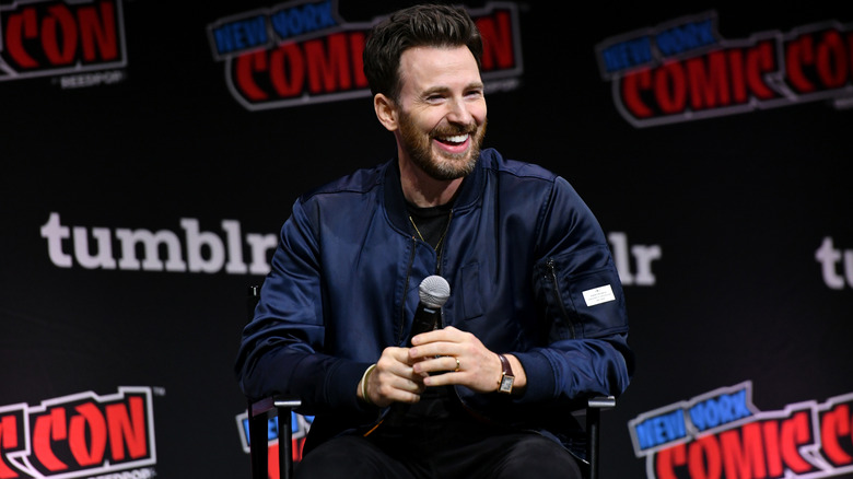 Chris Evans riendo con micrófono en el escenario