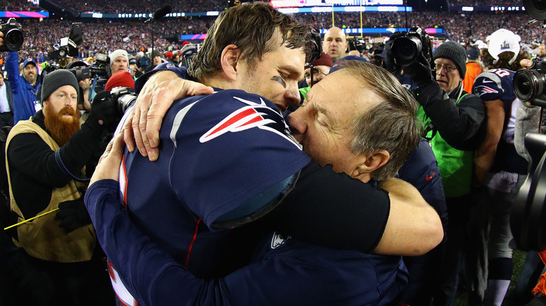 Bill Belichick y Tom Brady se abrazan en el campo de fútbol